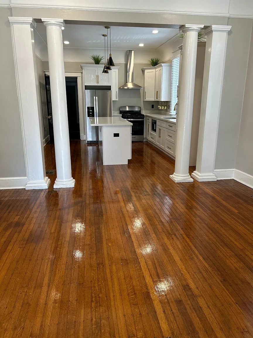 Open living area with columns looking into the renovated kitchen