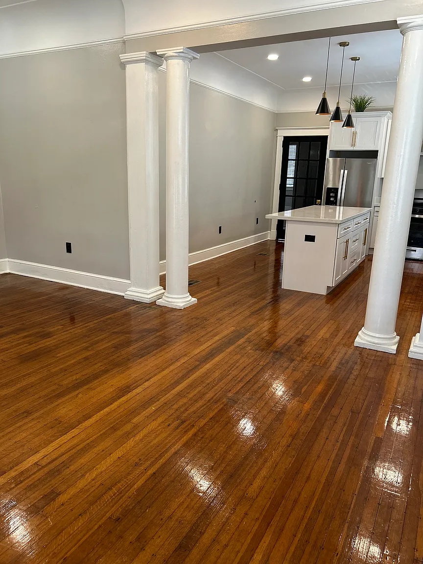 Spacious living room with hardwood floors and columns