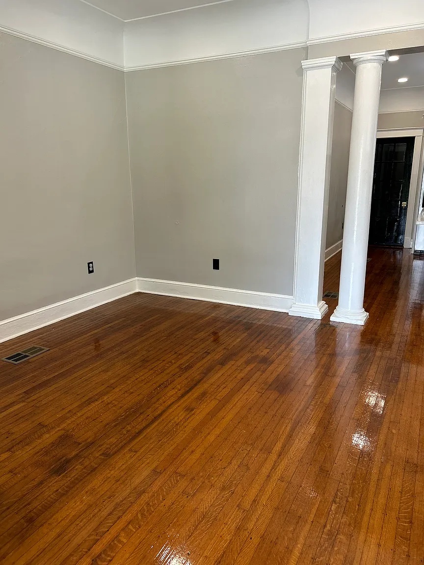 Front room with classic columns and hardwood floors